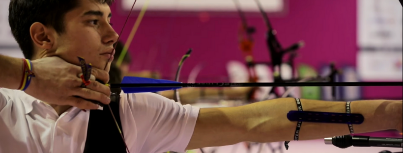 a teenage archer shooting a bow and arrow in a side view