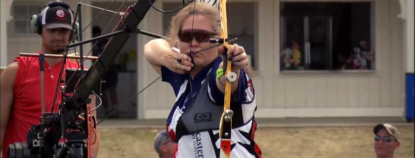a professional archer women with sunglasses is shooting a bow and arrow